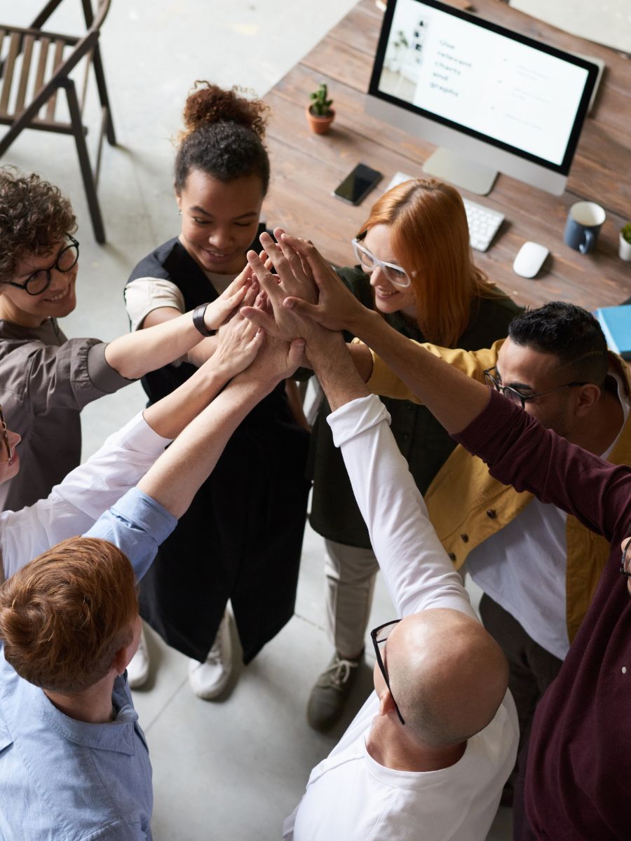 Coworkers high-fiving in a circle 